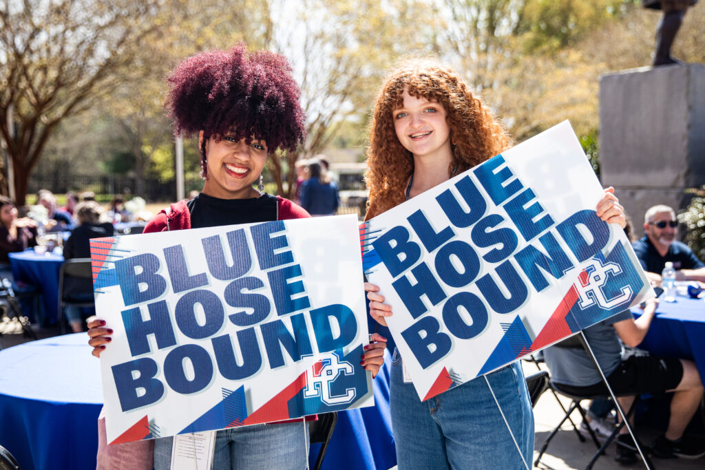 Girls holding "Blue Hose Bound" signs at Accepted Student Day
