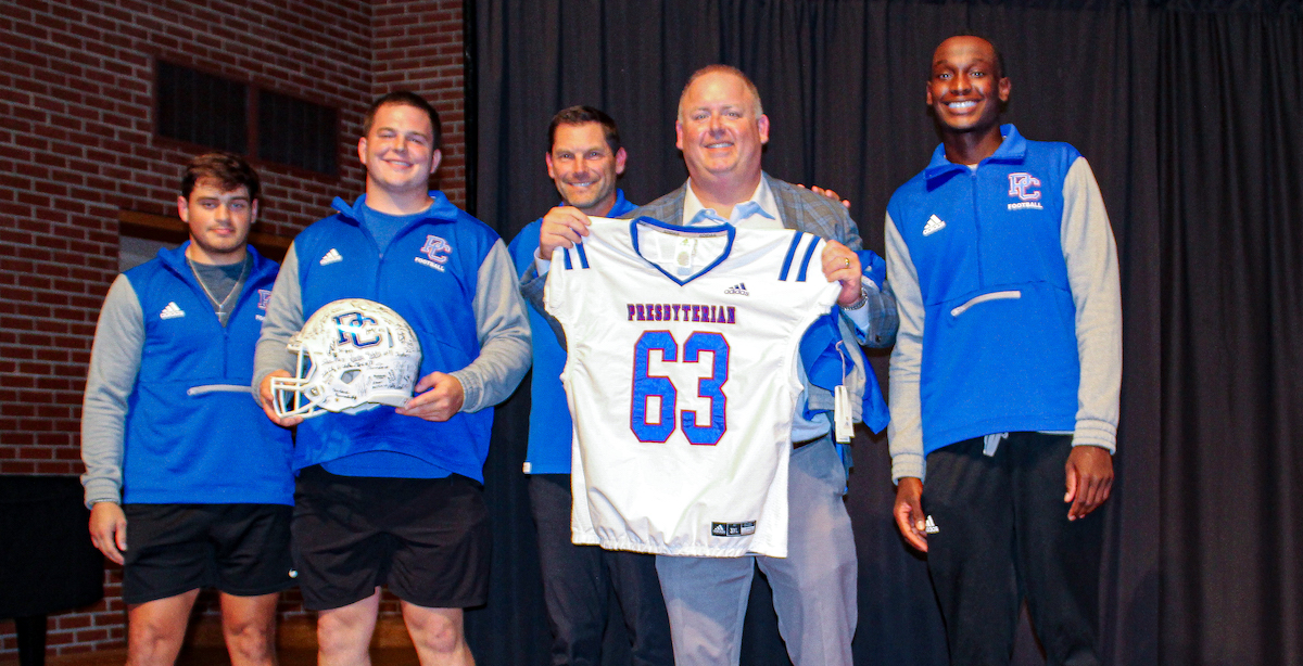 Kevin Nolan with Coach Steve Englehart and Blue Hose football players.