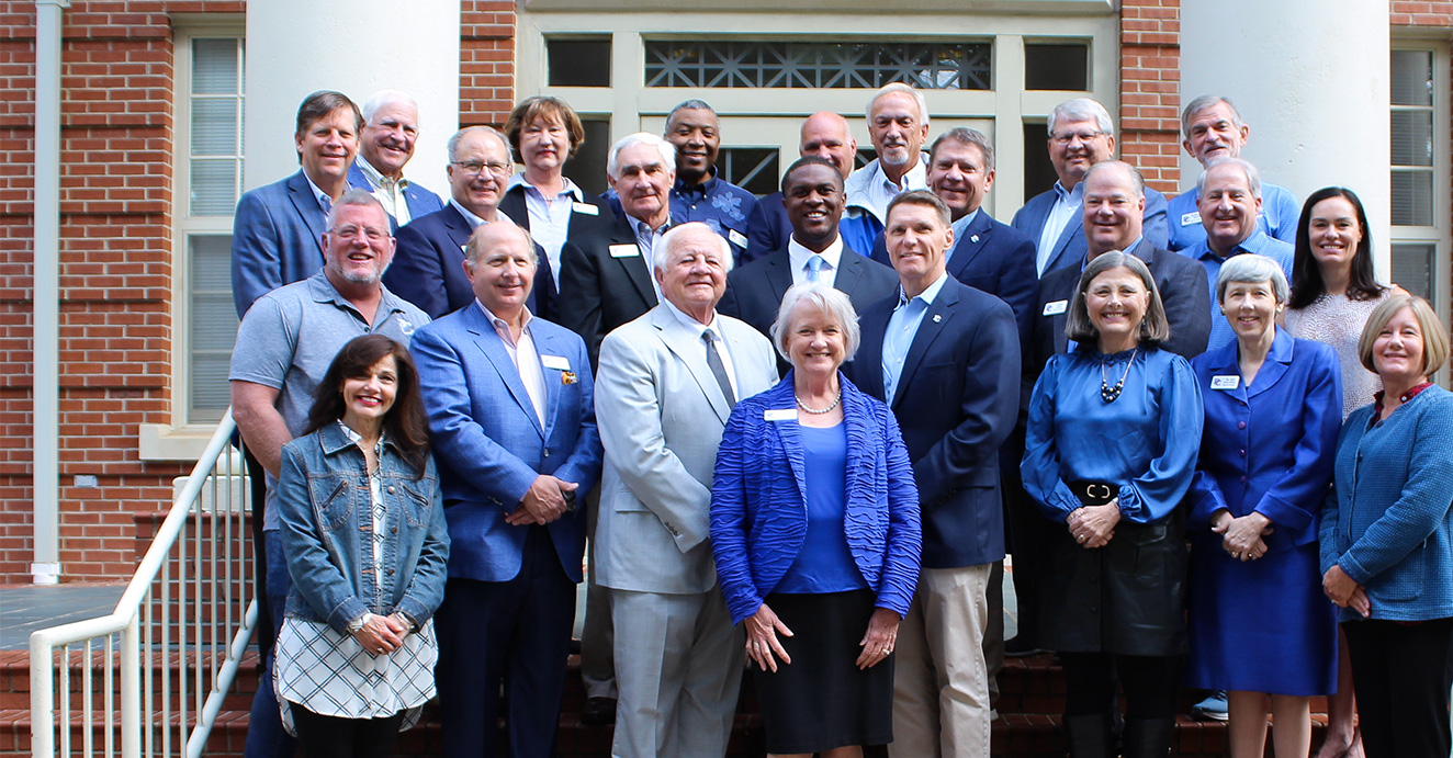 President Dr. Anita Olson Gustafson pictured with members of PC's Board of Trustees in front of HP staircase