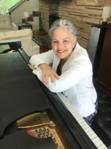 Dr. WEndy Freeland sitting at a piano