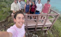 Student takes a selfie with her group and professors during one of the student's trip