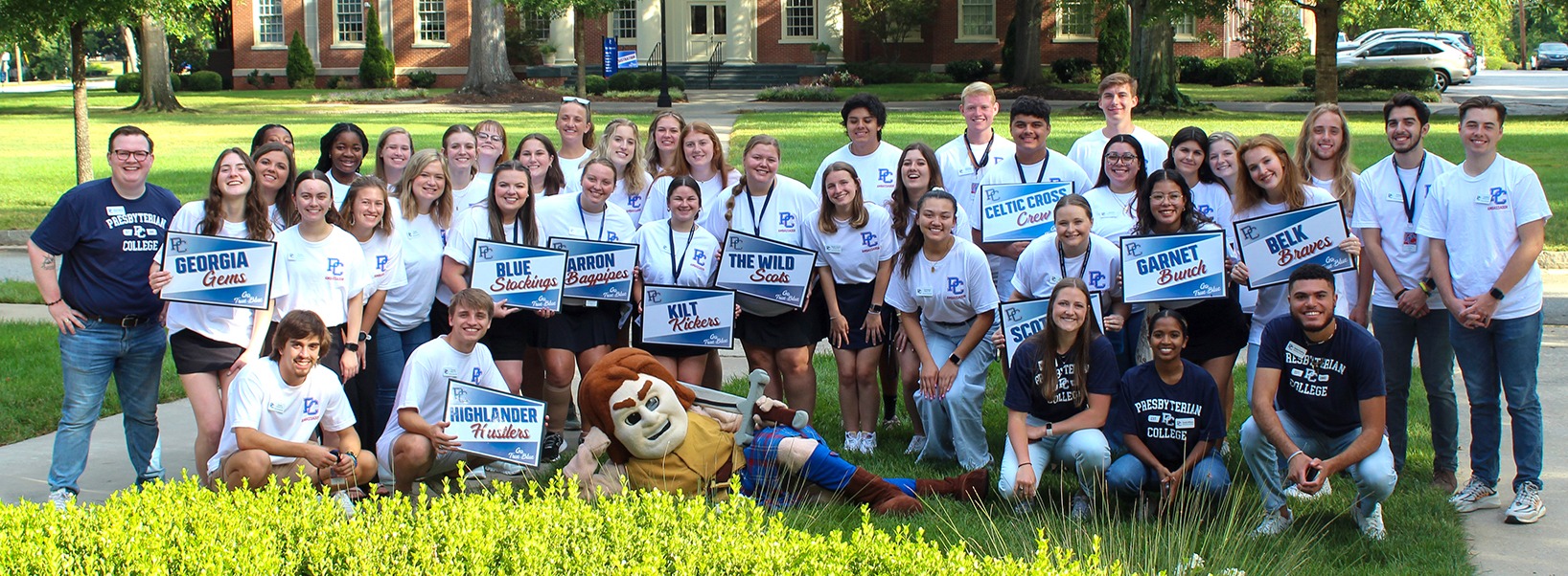 Group photo of student ambassadors and Scotty on the lawn in front of Smith Administration Building