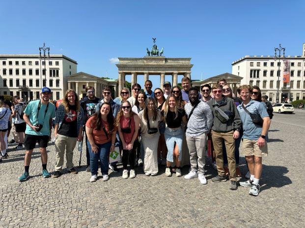 Students lined up for a photo in front of a historic structure