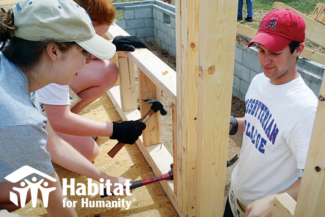 Students with hammers helping to built a house
