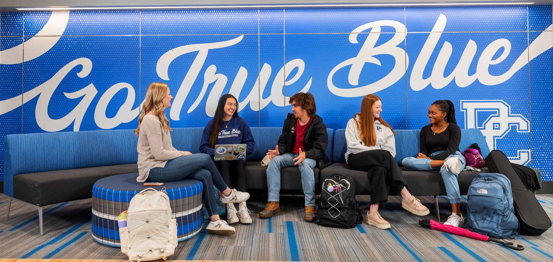 Presbyterian College Students in Springs Student Center in front of Go True Blue wall