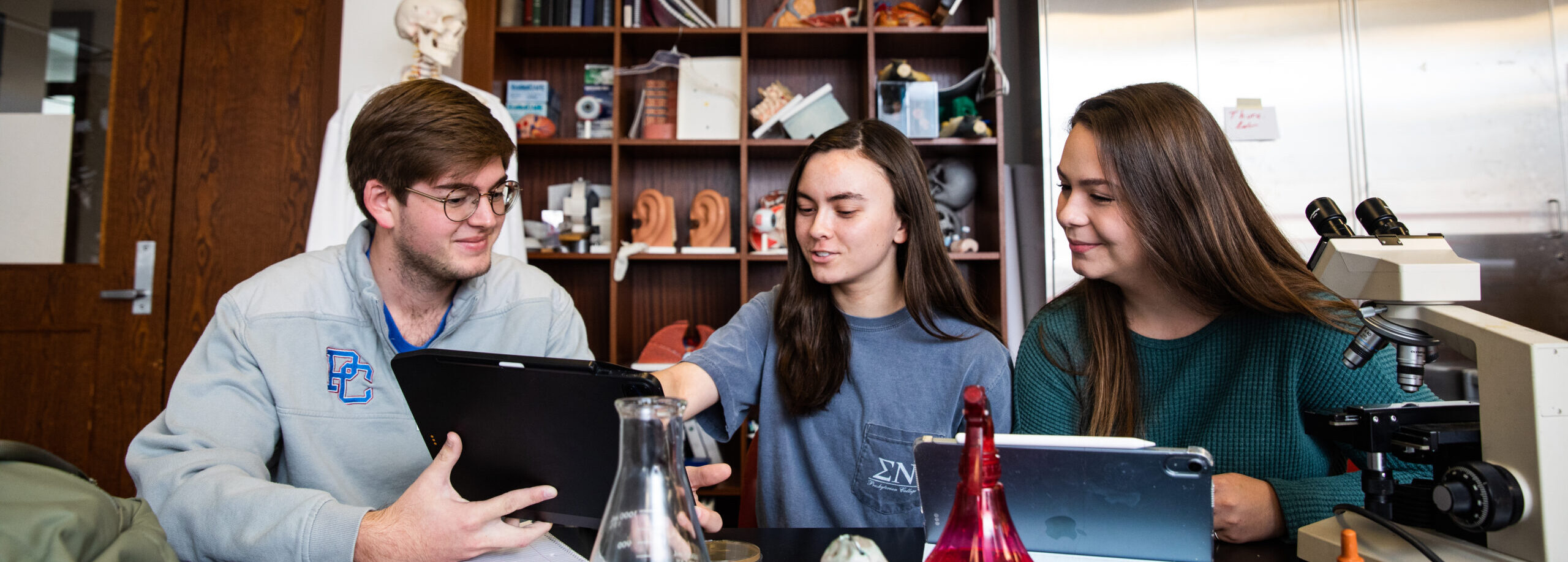 Biochemistry students smiling and talking in a science lab at Presbyterian College.
