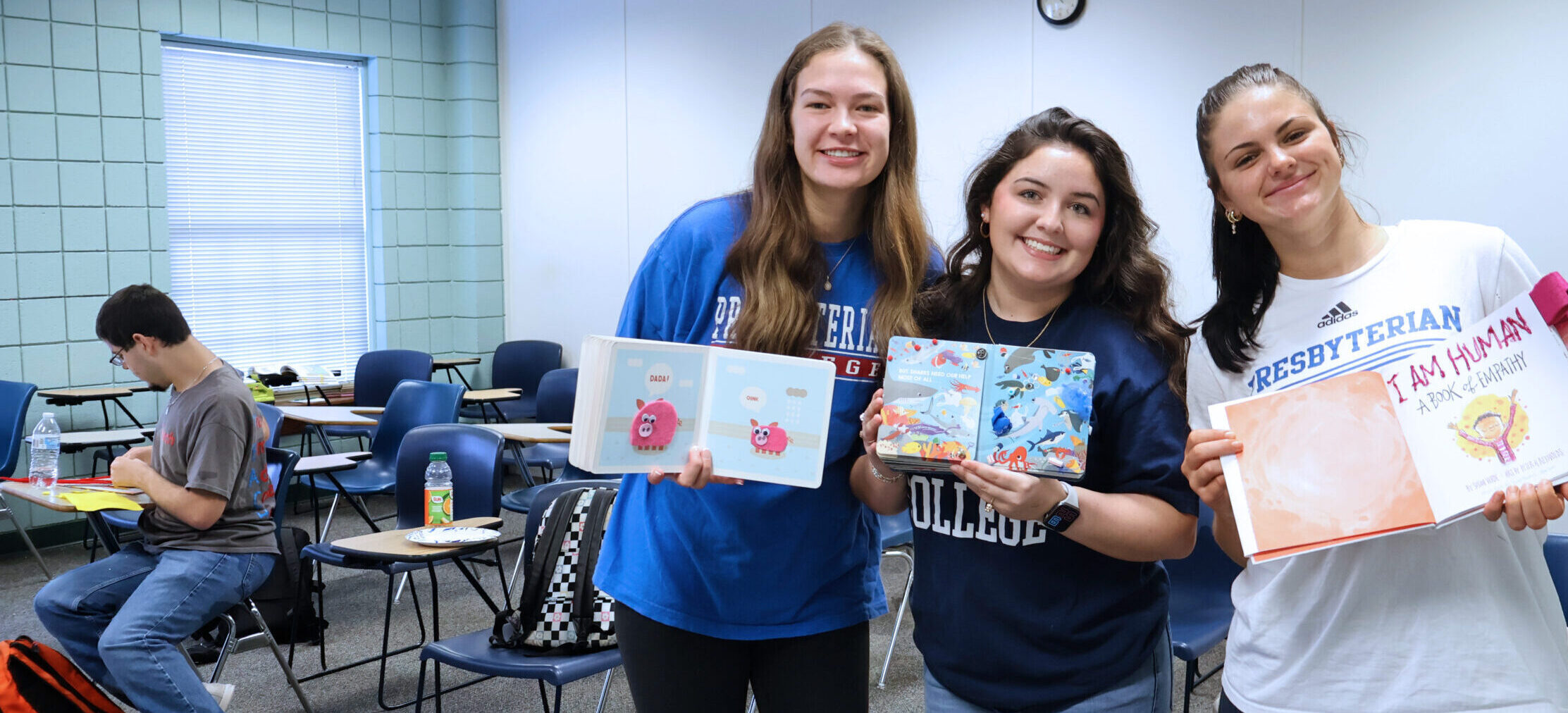 Presbyterian College Special Education major students holding children's books and smiling.