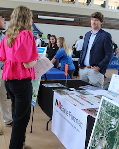 PC alumnus Will Williamson speaks with PC students at career fair.