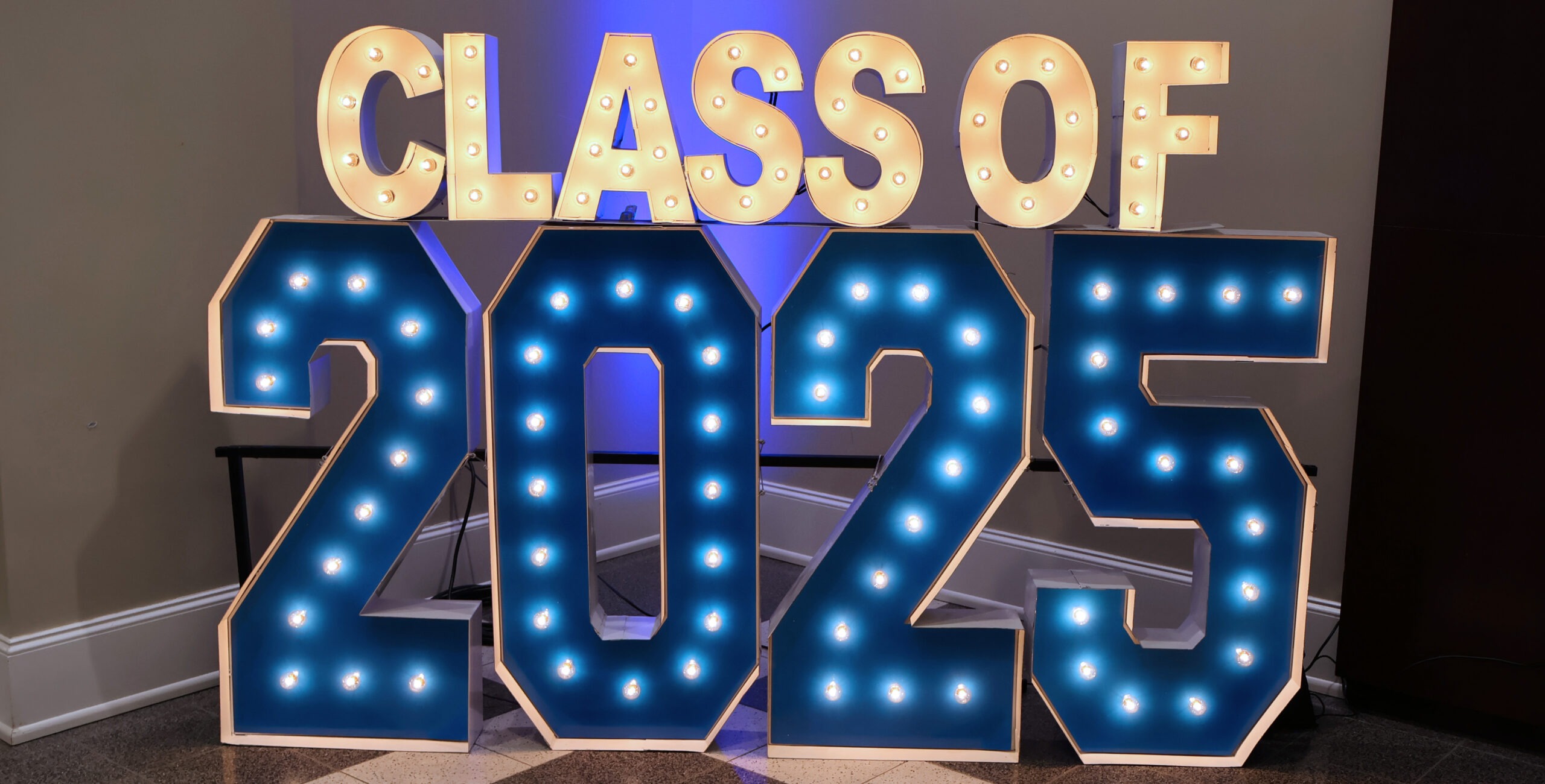 Class of 25 light up stand at an event.