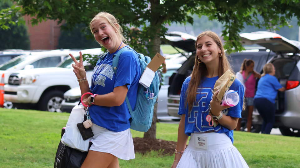 Two Presbyterian College students walking and smiling at New Student Move-In Day