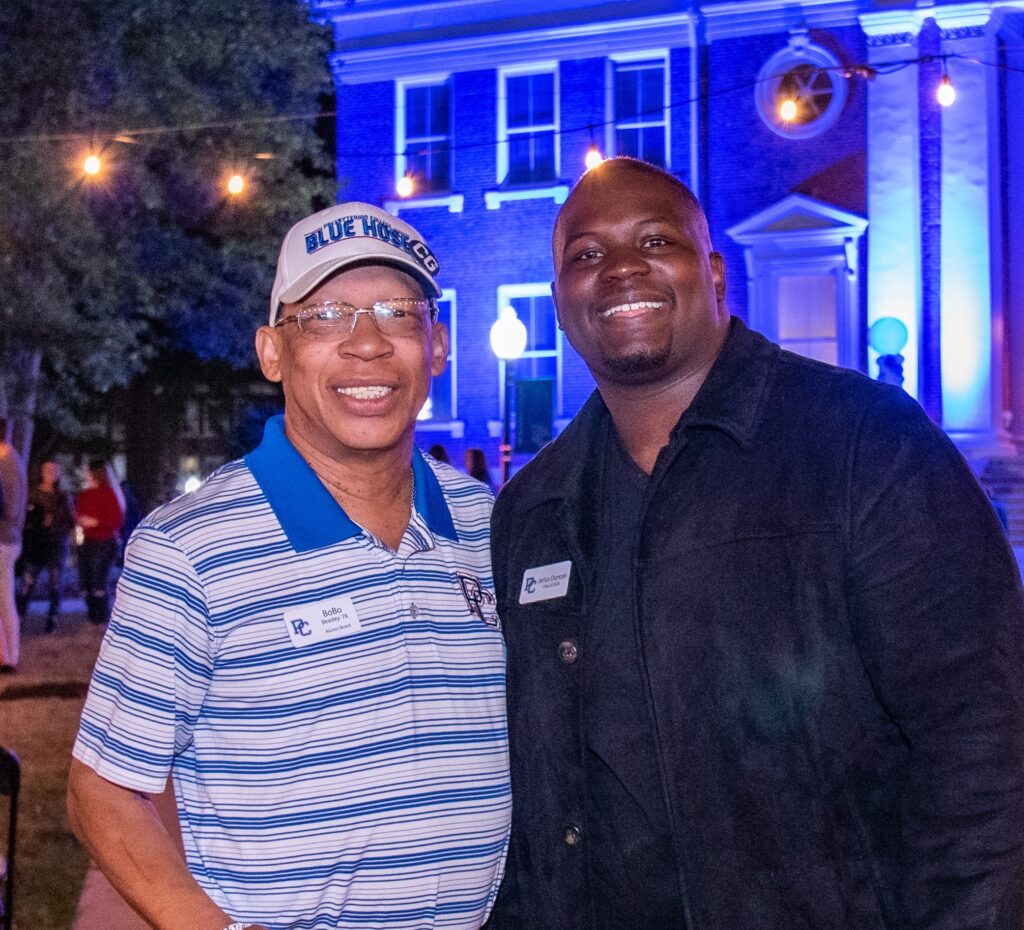 Alumni posing and smiling for a photo at Homecoming at Presbyterian College.