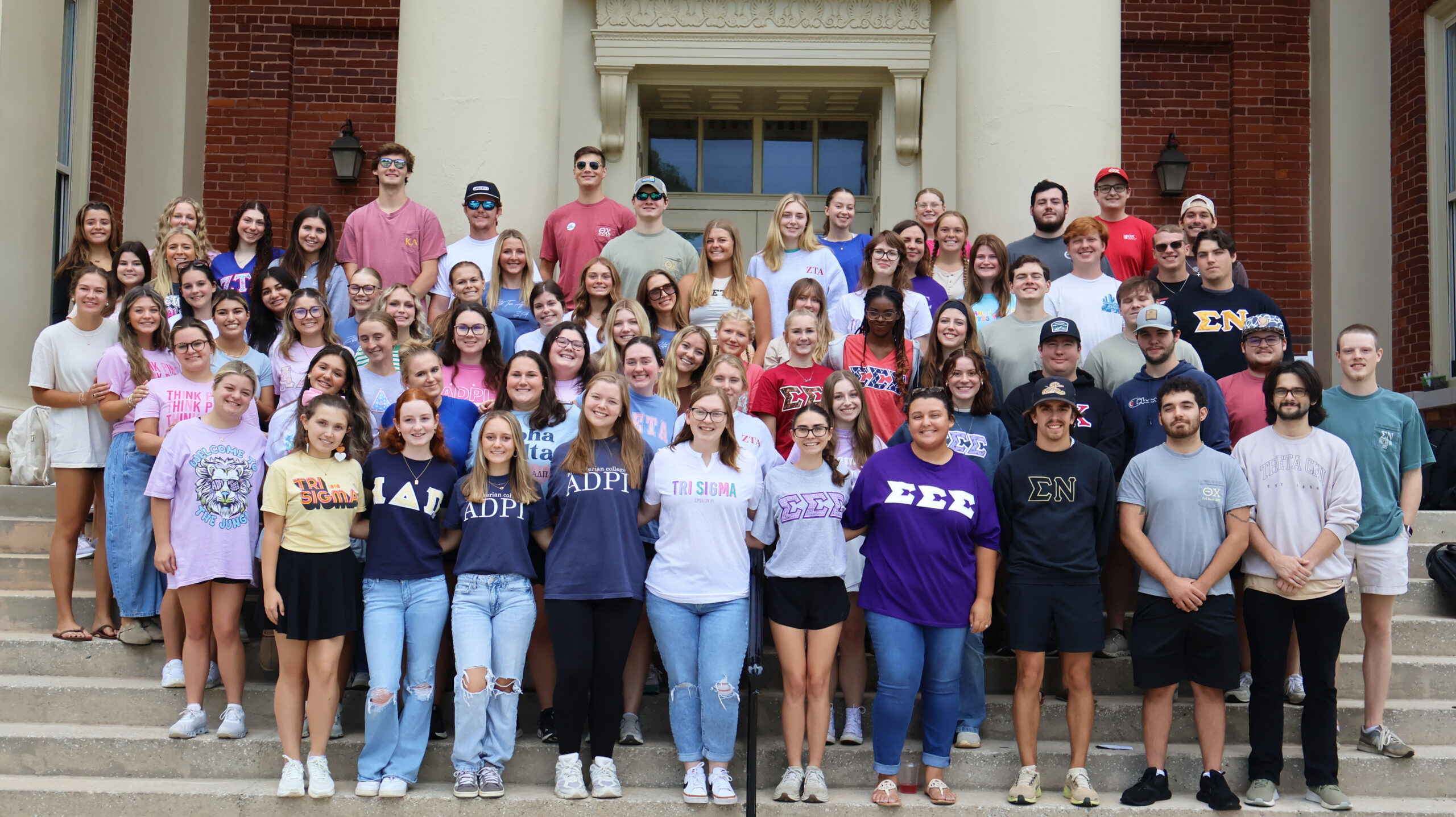 Presbyterian College students involved in Greek Life pose for a picture on the steps of Neville Hall.