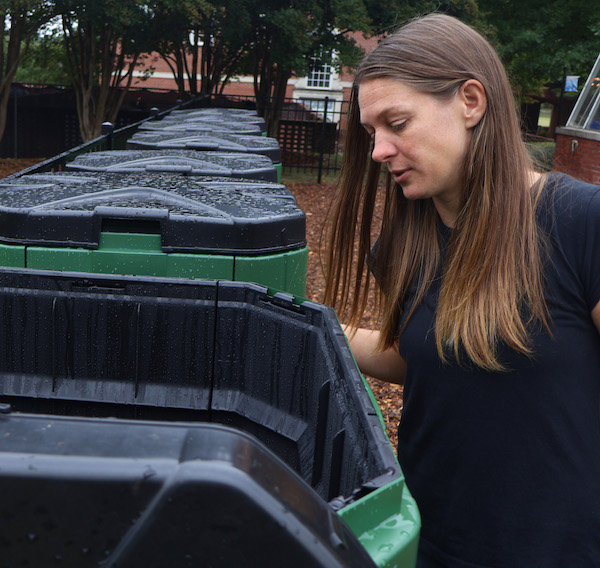 Dr. Sabrina Moore examining progress in one of the donated composting bins at PC's Eco Hub.