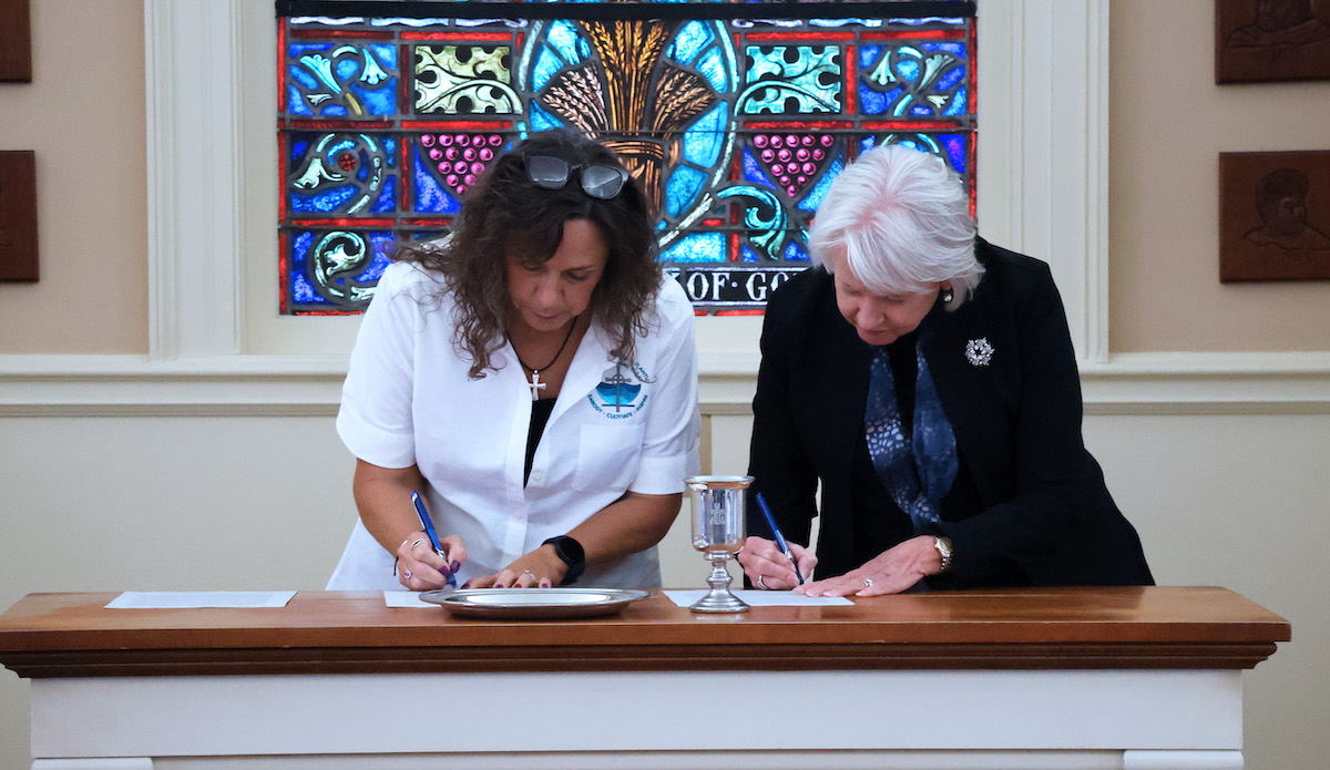 Synod of the South Atlantic executive Valerie Young and PC president Dr. Anita Gustafson sign the newest covenant between the two entities.