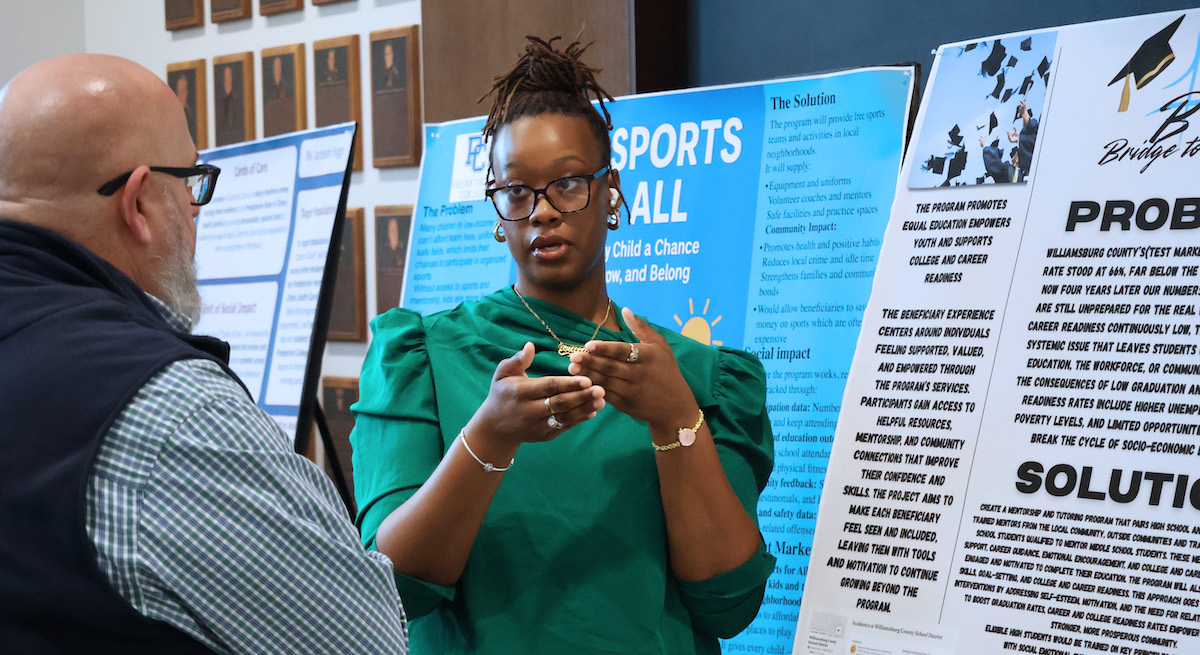 PC freshman Anya Mack discussing her tutoring and mentoring program at the service entrepreneurship class' poster presentation.