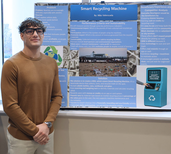 PC freshman Niko Valenzuela showing his poster proposing a smart recycling machine to incentivize trash cleanup on the beaches of Southern California.