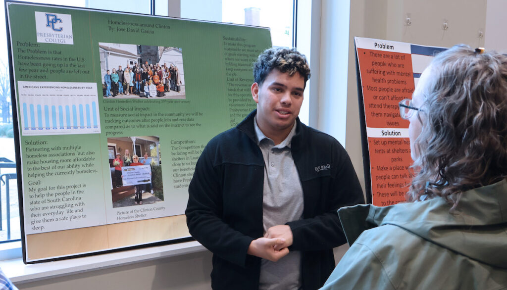 PC freshman Jose David Garcia discusses his solution to combat homelessness at the service entrepreneurship poster presentation.