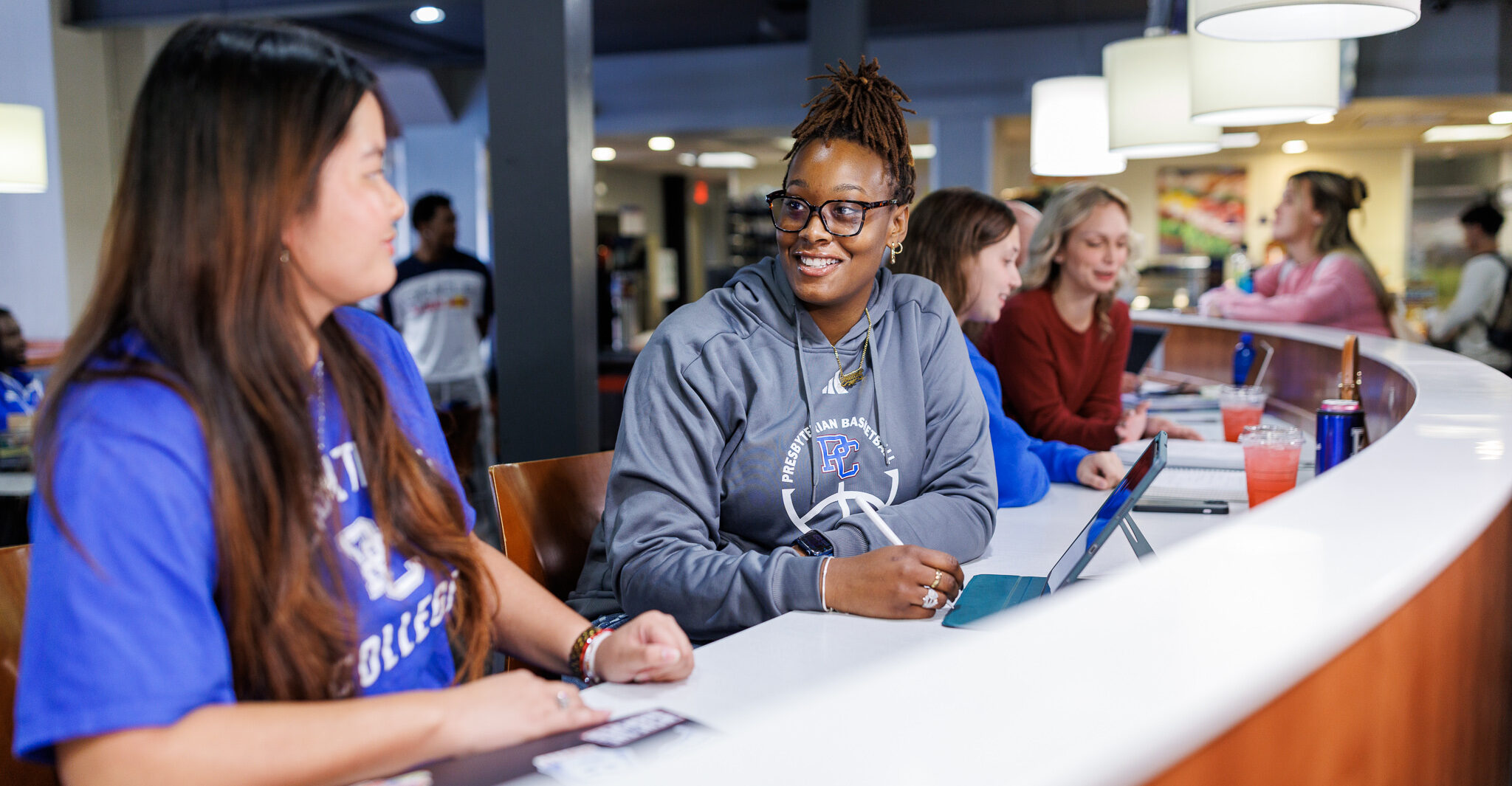 Presbyterian College students smiling and talking while working.