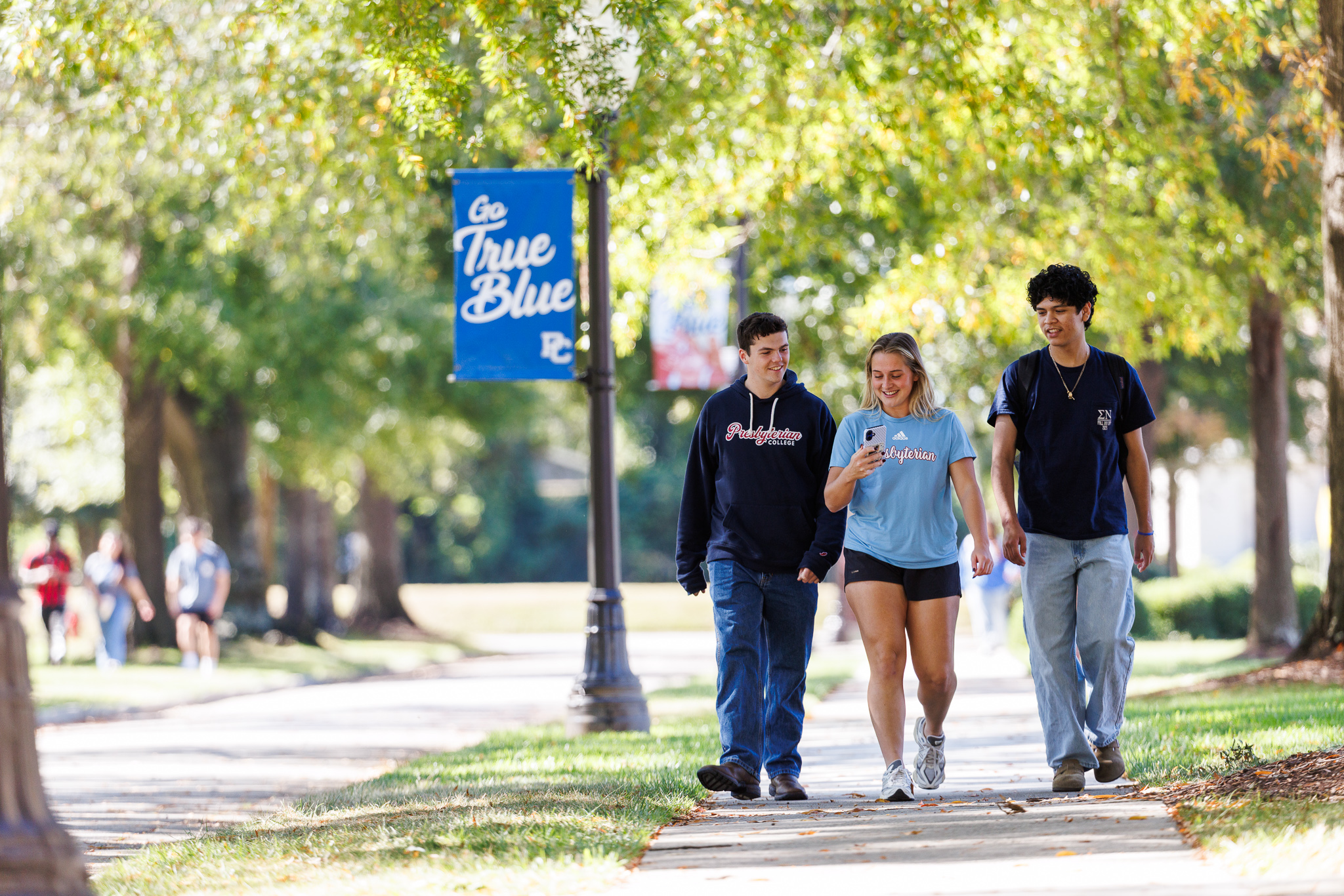 Three students walking and talking outside at Presbyterian College.