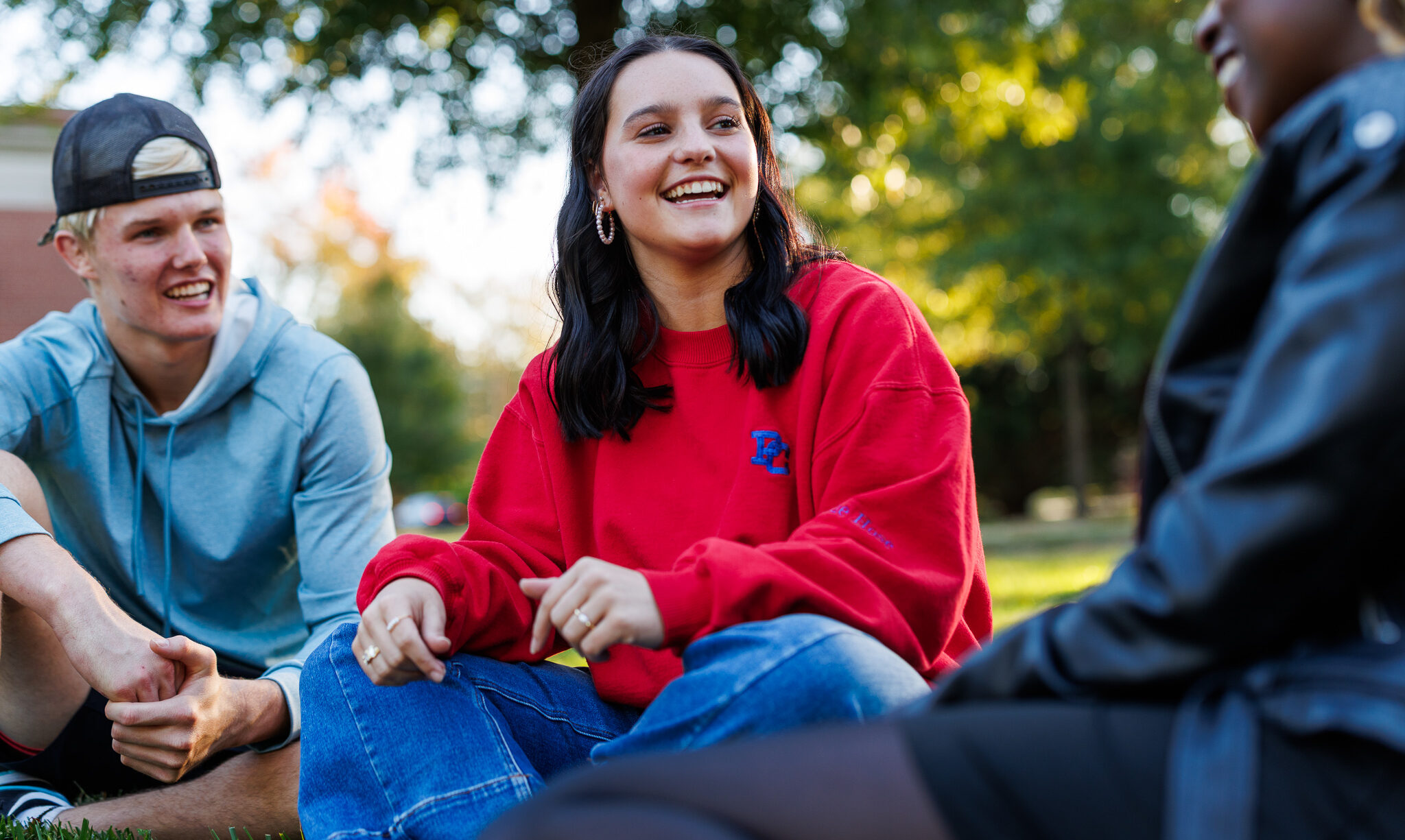 Three Presbyterian College students sitting outside and smiling