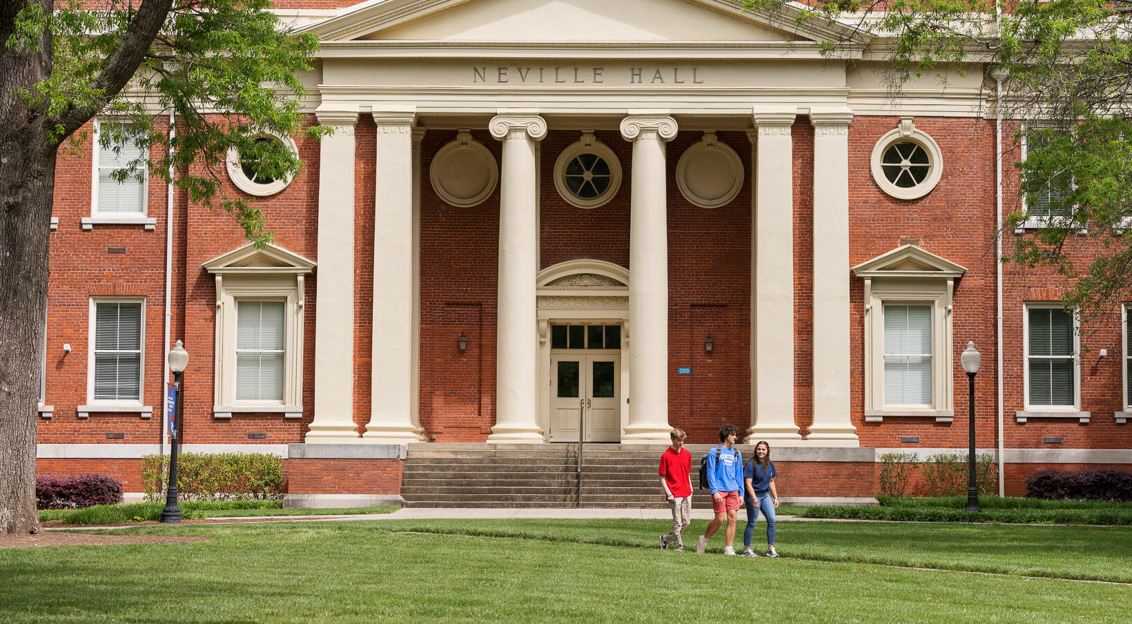 Three students walking in front of Neville Hall at Presbyterian College.