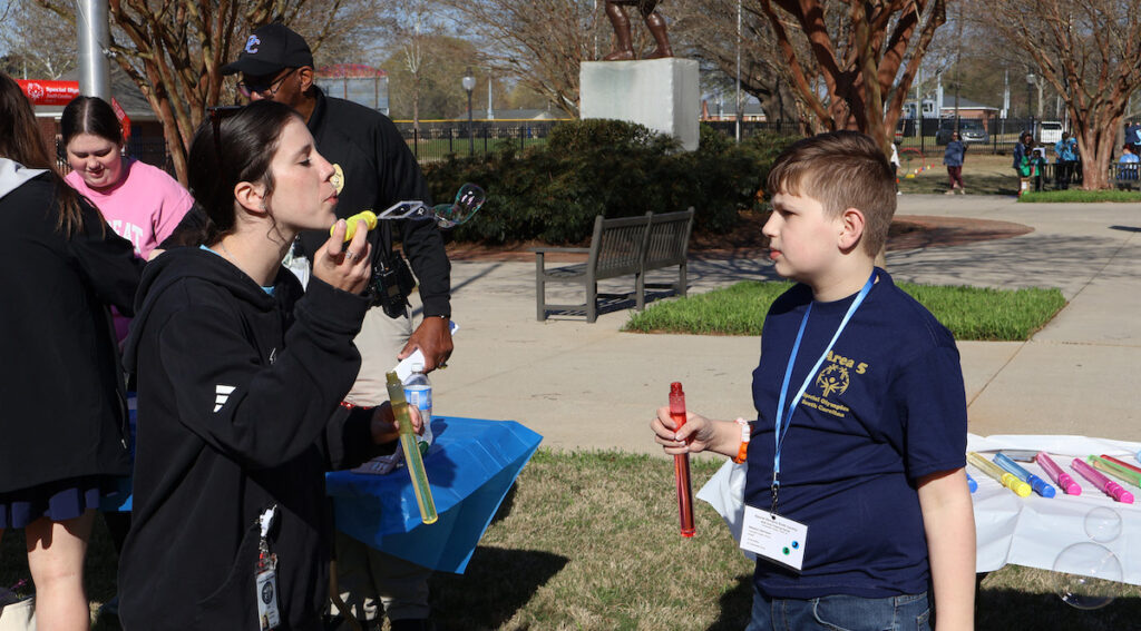 A Presbyterian College student volunteer blows bubbles during a break in the action at the 2026 Area 5 Special Olympics.