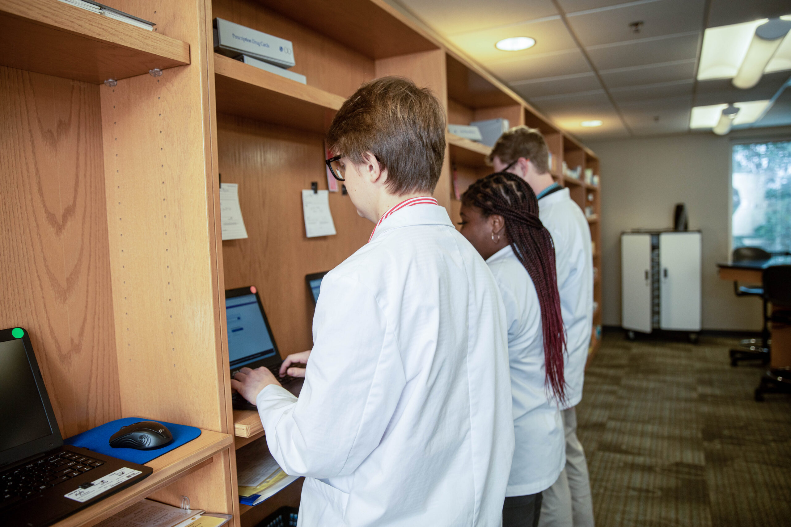 Pharmacy students doing work in a classroom.