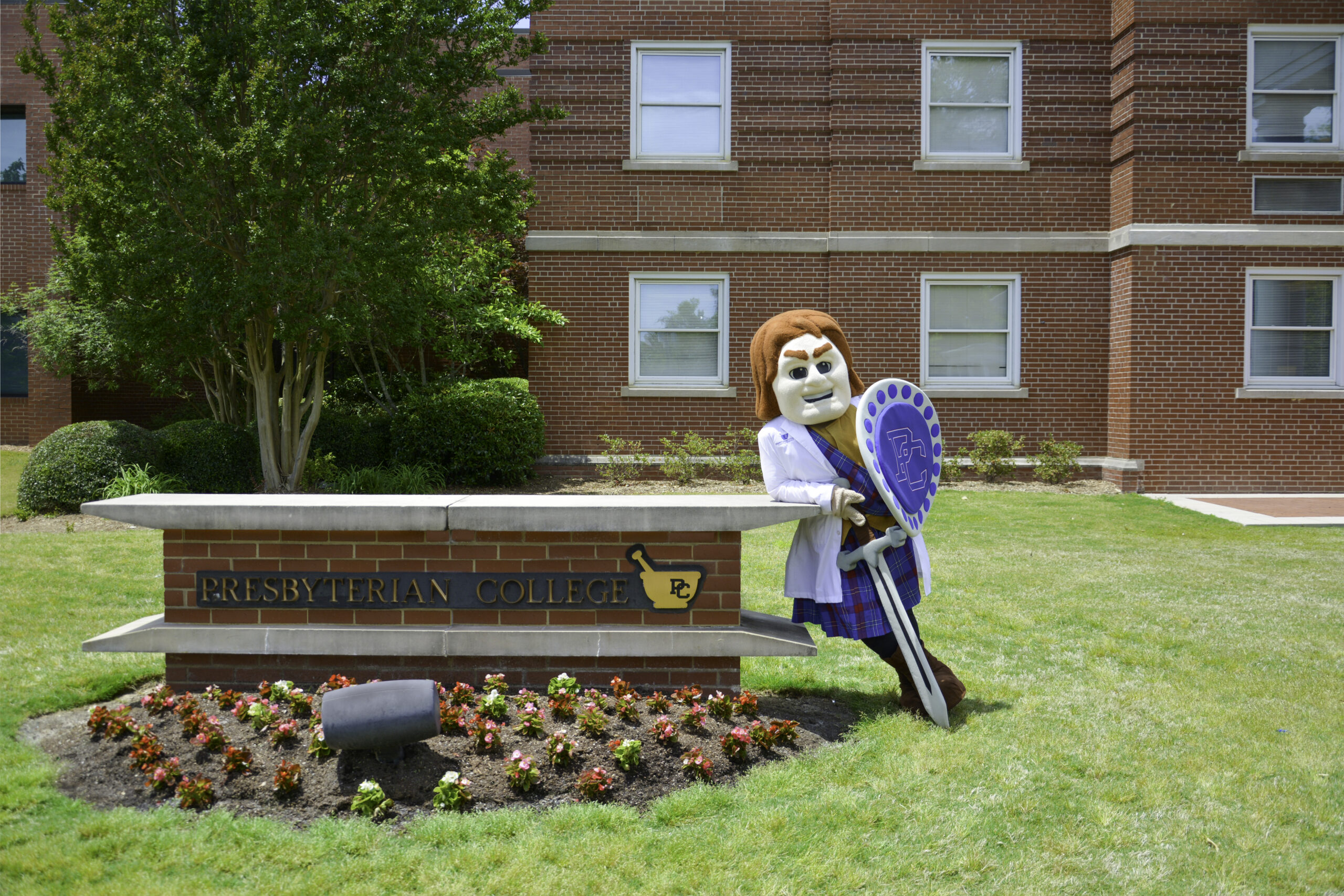 Scotty the Scotsman leaning on the Pharmacy School Sign