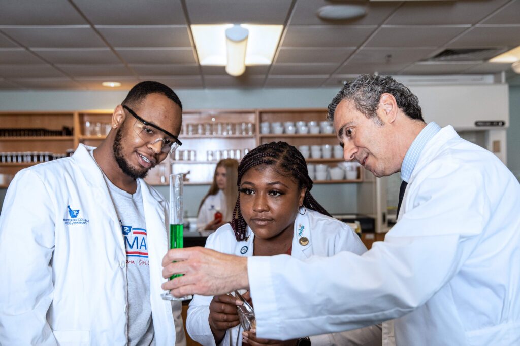 PharmD program students looks at a formula with Dr. Gumina. 