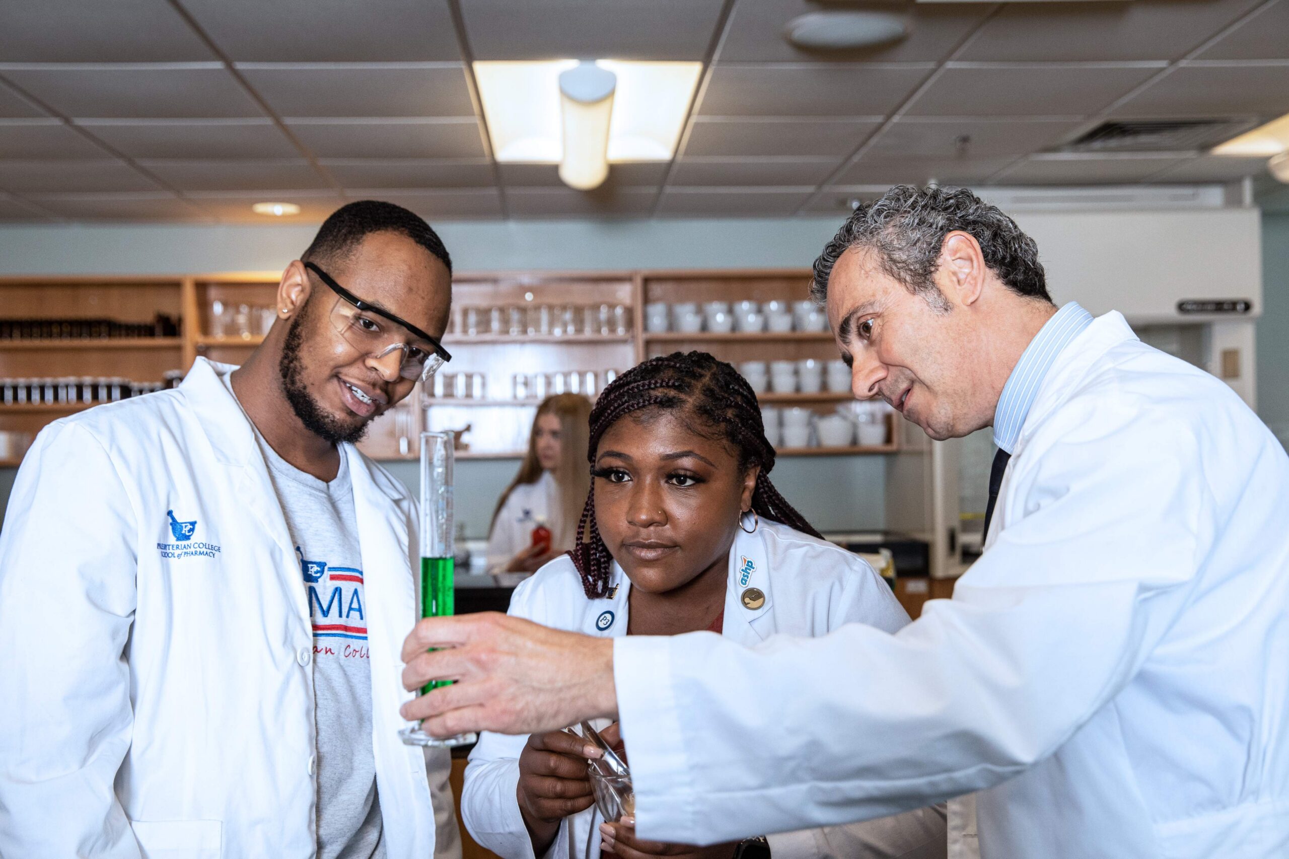 PharmD program students looks at a formula with Dr. Gumina.