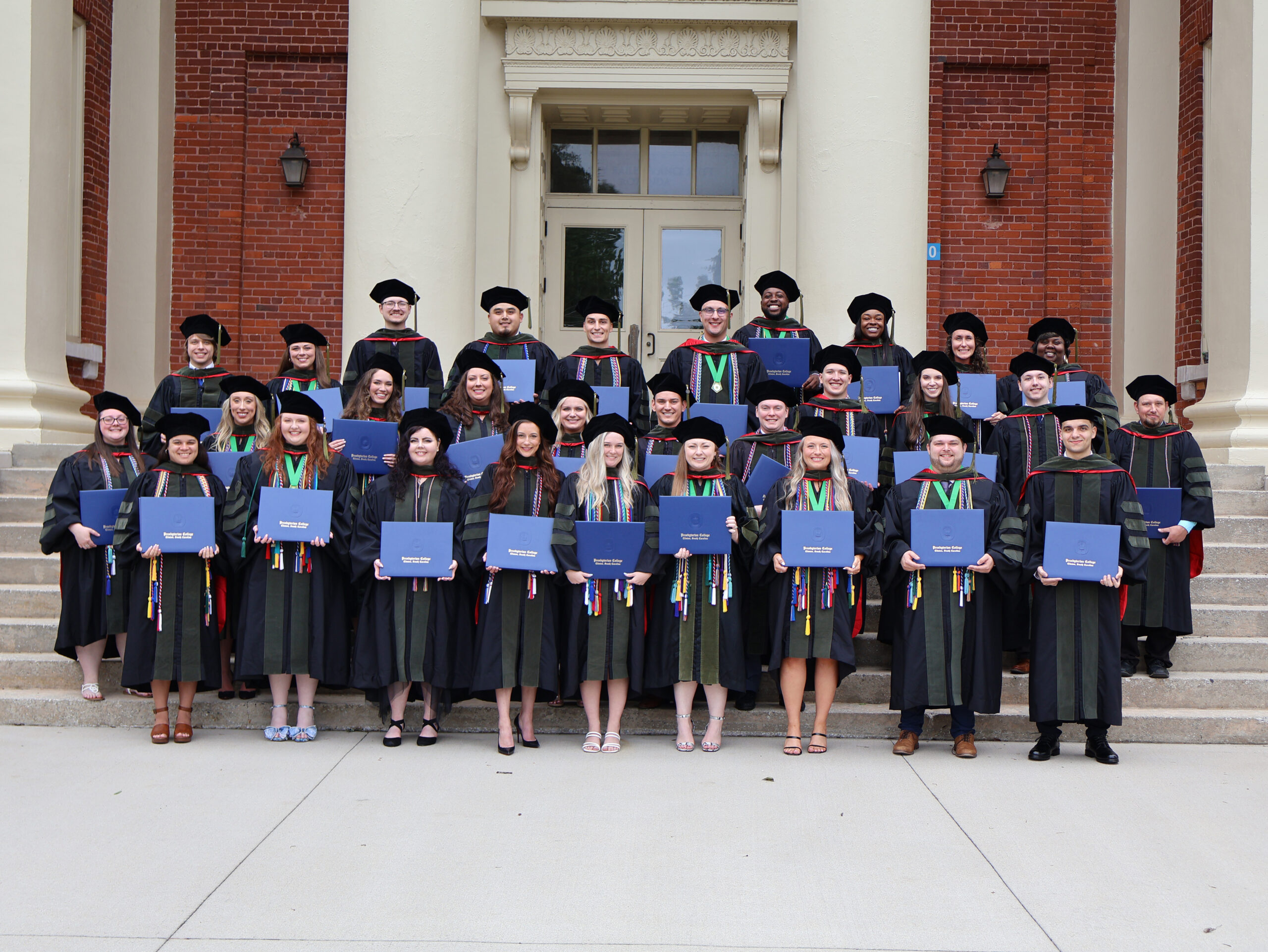 Pharmacy graduates pose with their diplomas at Neville Hall.