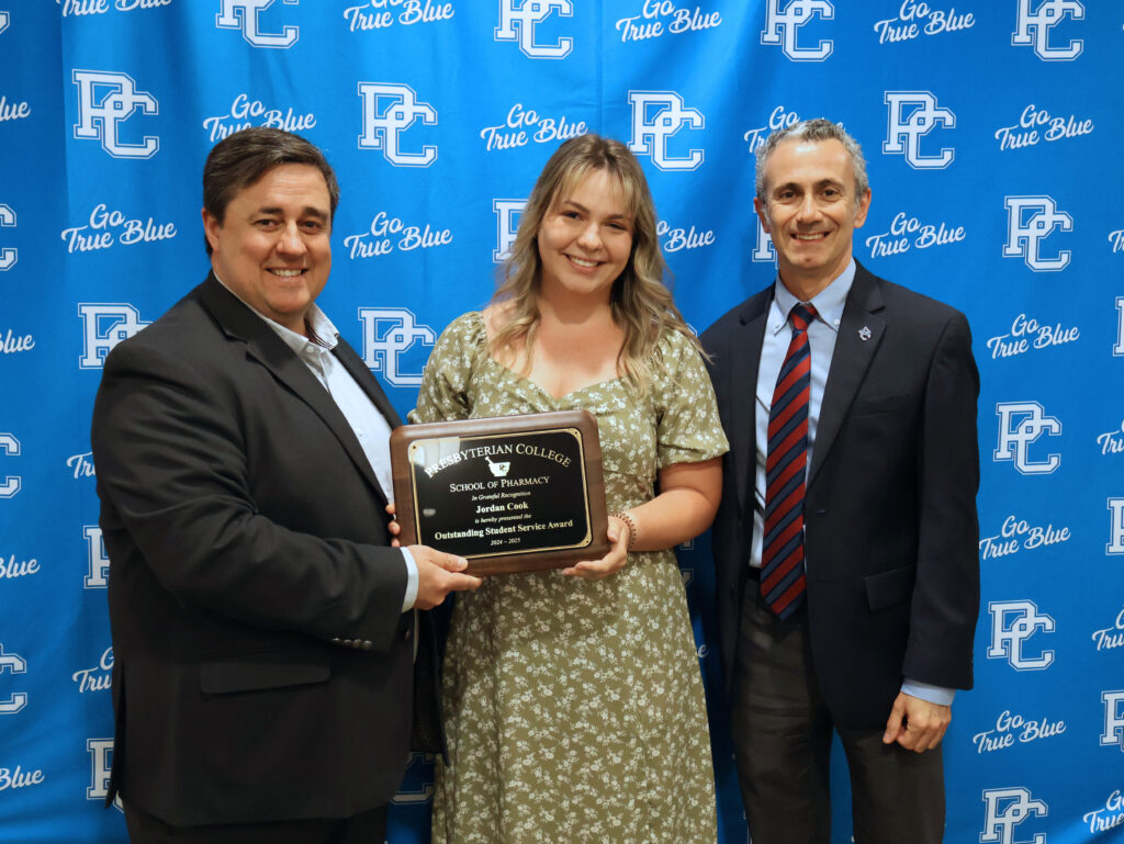 Photo of Pharmacy student Jordan Cook winning an award. Standing with Dean of Pharmacy, Giuseppe Gumina and Assistant Dean for Student Affairs, Scott Kincaid. 
