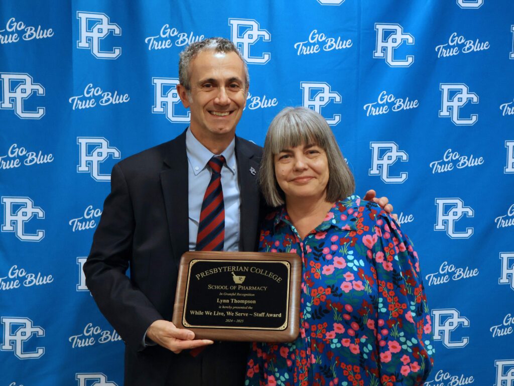 Dr. Giuseppe Guimina poses with an award presented to Lynn Thompson.