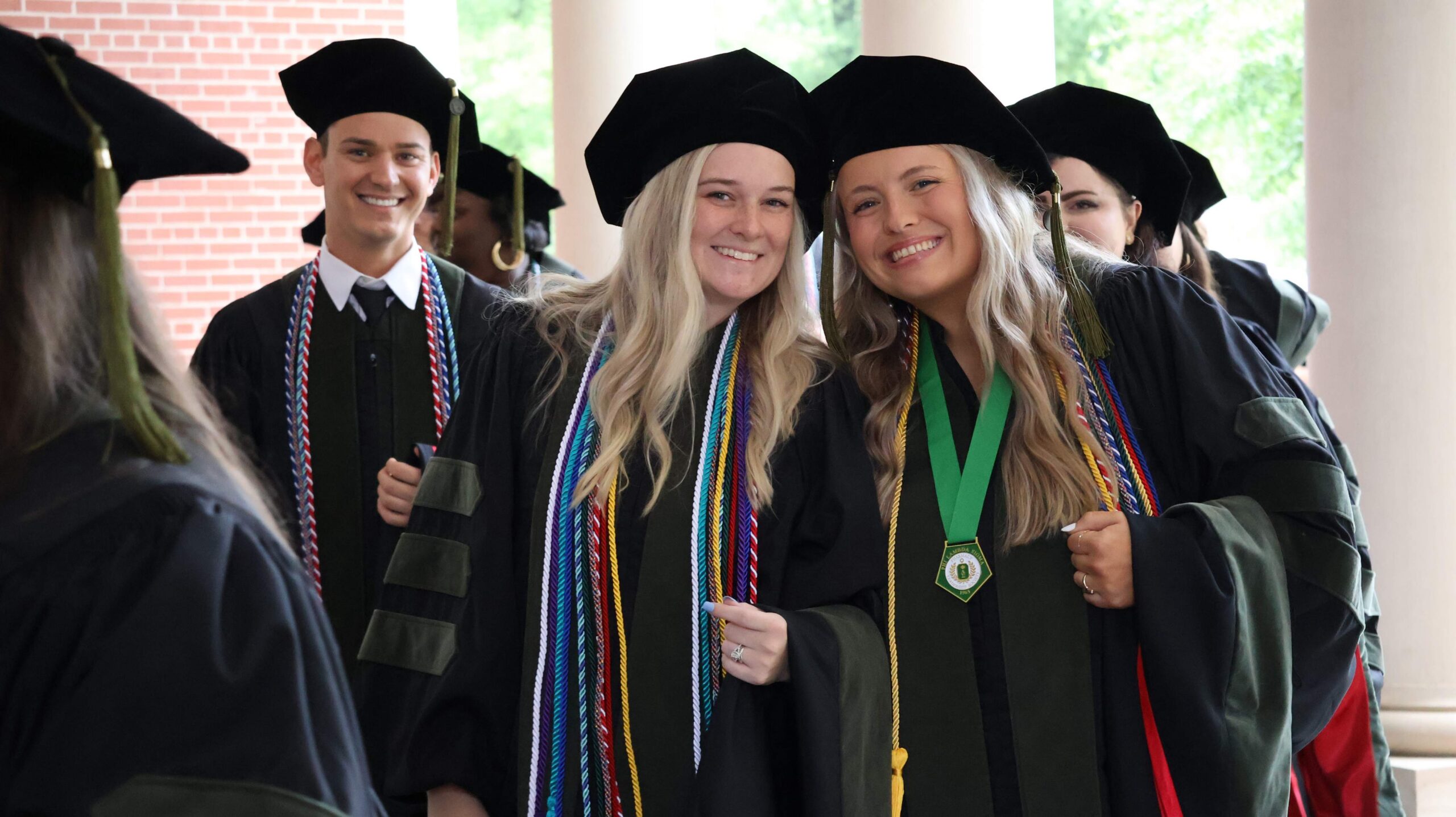 Pharmacy students smiling after their hooding ceremony.