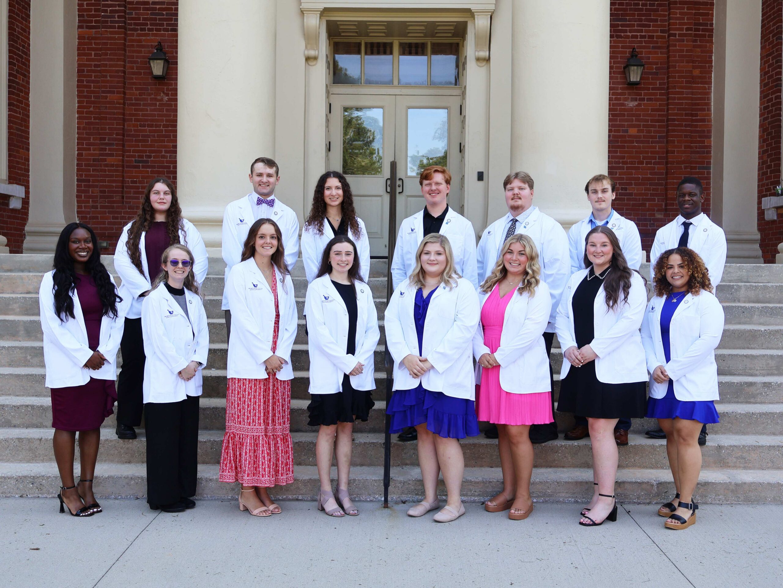 Pharmacy students pose for a group picture with their new white coats.