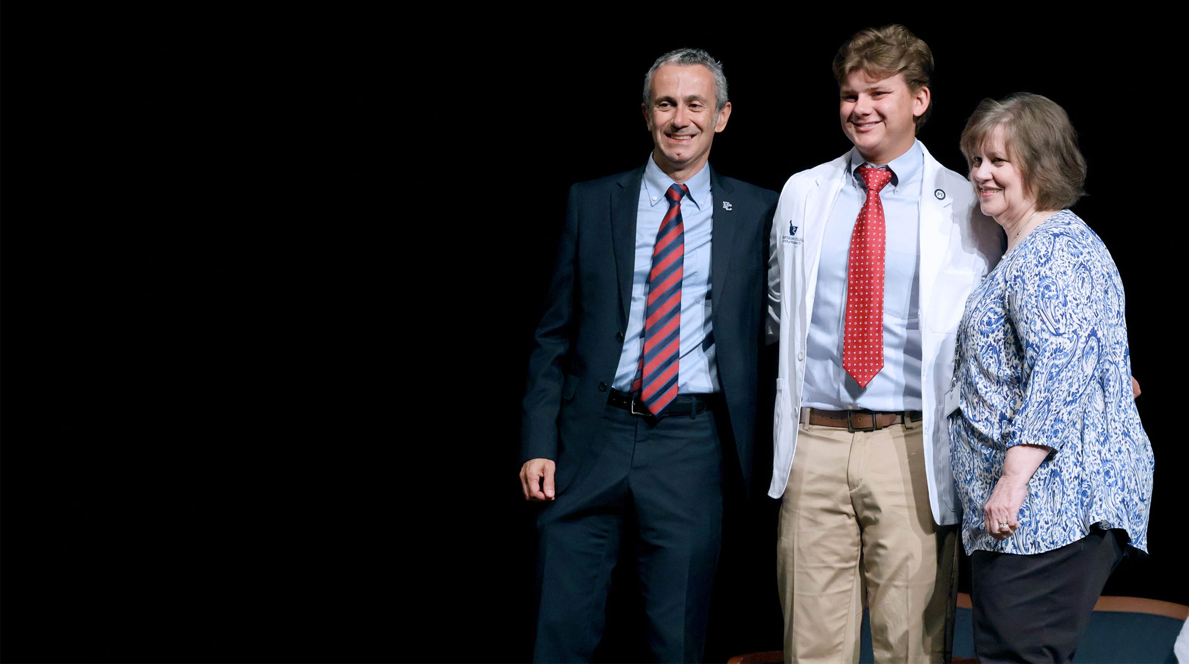 Pharmacy student poses with new white coat.
