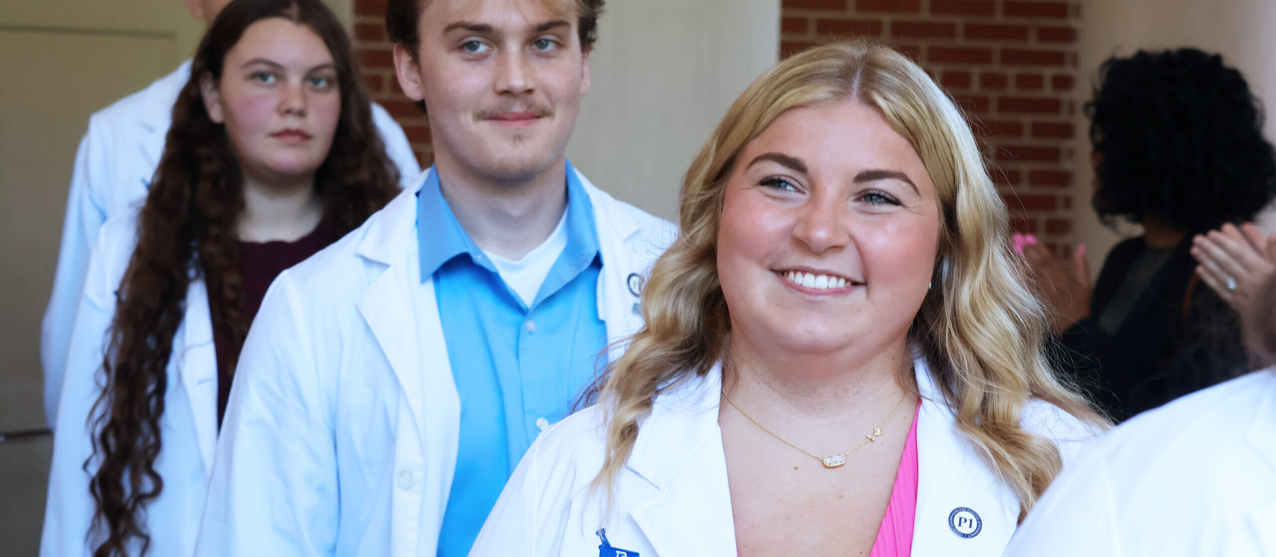 Pharmacy student smiles after receiving her white coat.