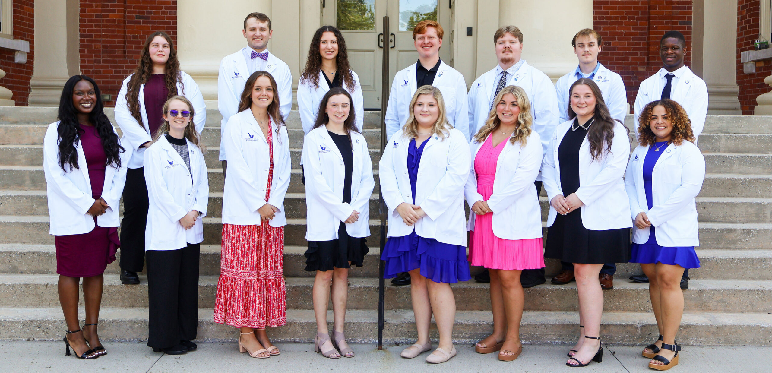 Pharmacy students pose for a group picture with their new white coats.