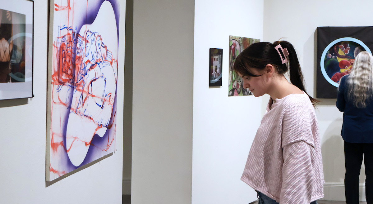 A Presbyterian College students enjoys looking at her fellow students' work at the college's annual student art exhibition.