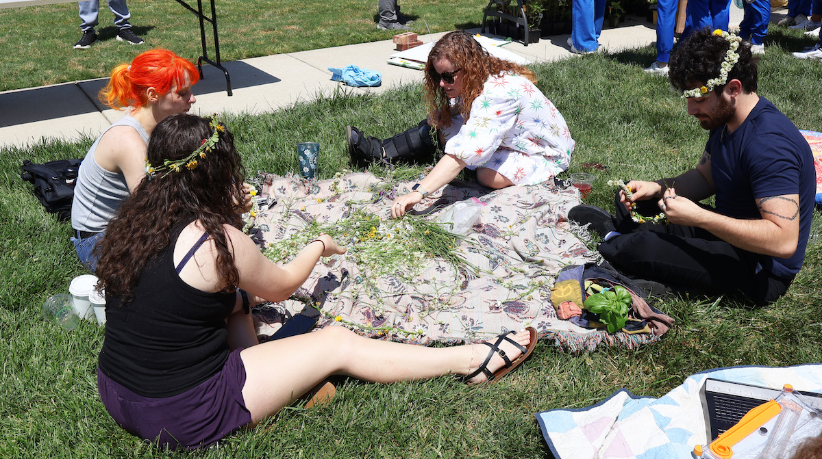 Making daisy wreaths in front of Neville Hall during Earth Day '26 at Presbyterian College.