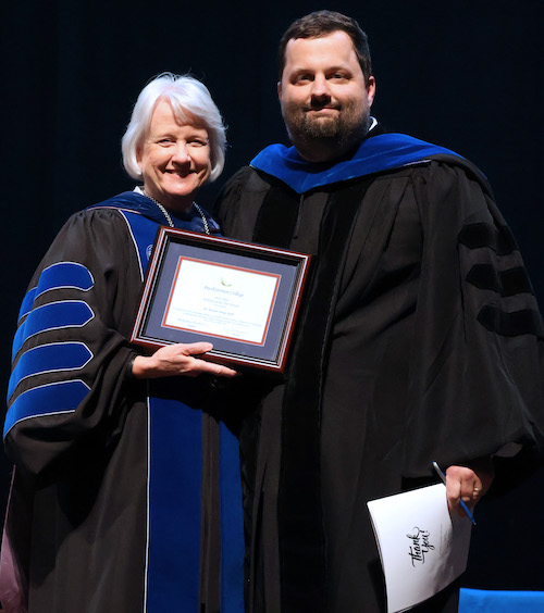 Biology professor Dr. Austin Shull '11 is presented with the 2026 Professor the Year award by PC president Dr. Anita Gustafson.