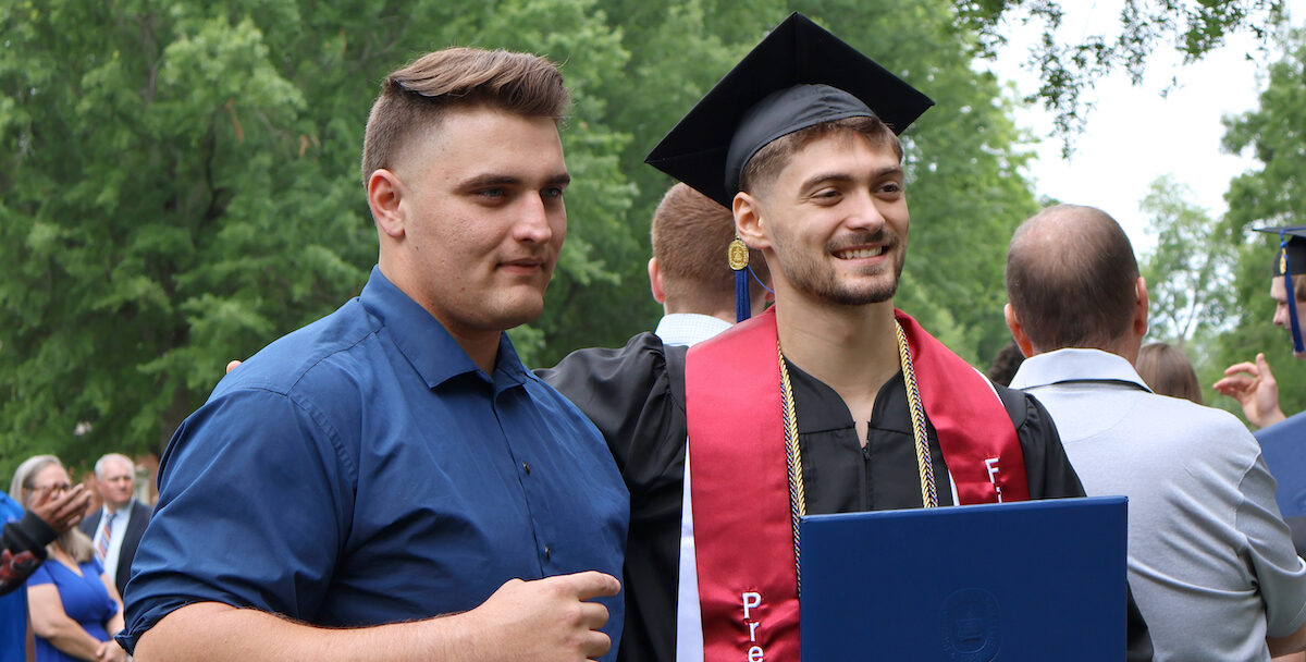 A proud first-generation college graduate poses for pictures following Presbyterian College's commencement celebrating the liberal arts.