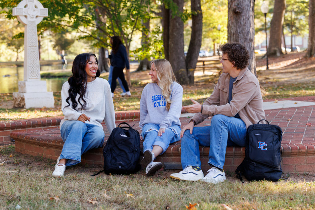 Three students sitting outside and talking at Presbyterian College