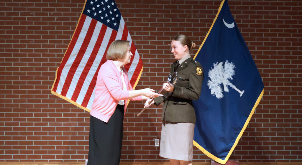 Cynthia Ivey, the granddaughter of former ROTC leader Col. Robert Wysor, presents this years Wysor Saber Award to Cadet Ashley Flynn.