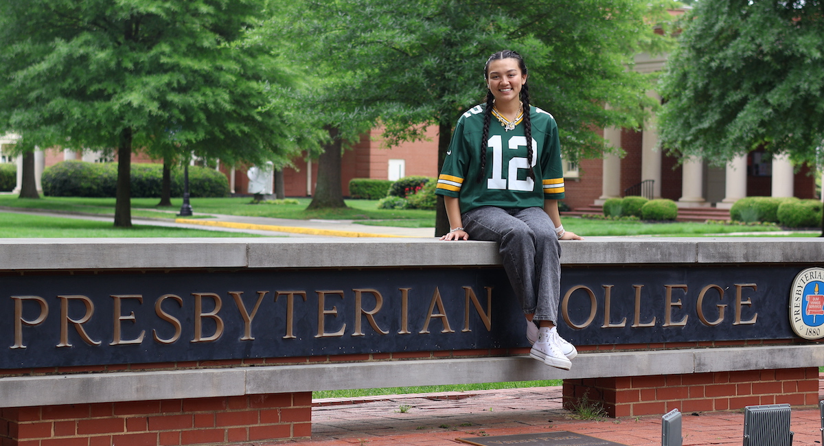 Vanessa Palisin, a recent graduate of Presbyterian College, poses on the college entrance sign in a Green Bay Packers jersey in anticipation of her internship with the NFL franchise.