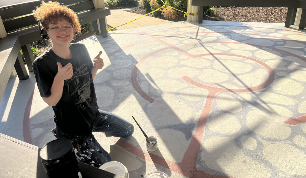 PC art major Lauren Smoak painting the labyrinth in the college's new Peace Pavilion.