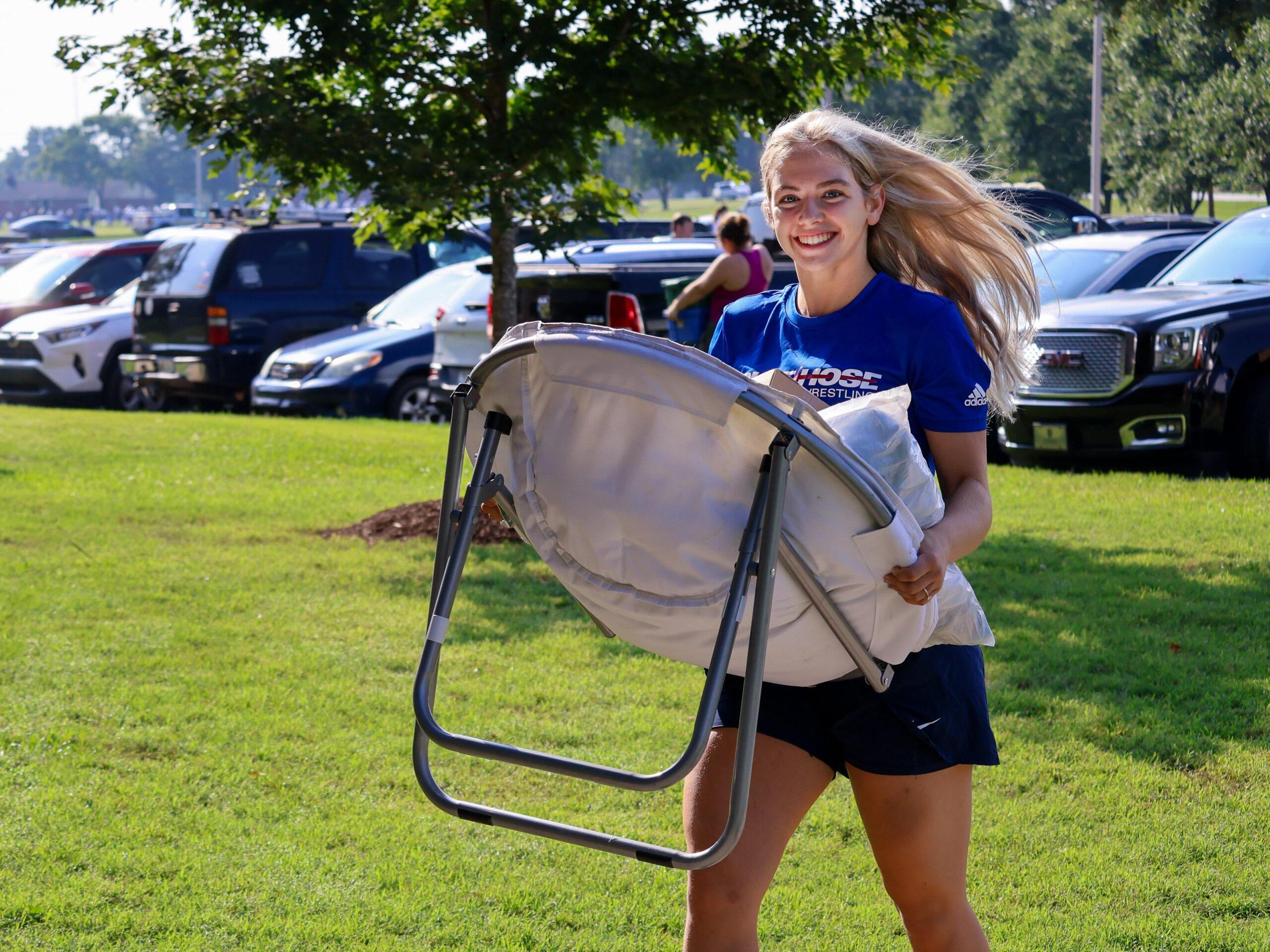 PC Student carrying a chair during move in day.