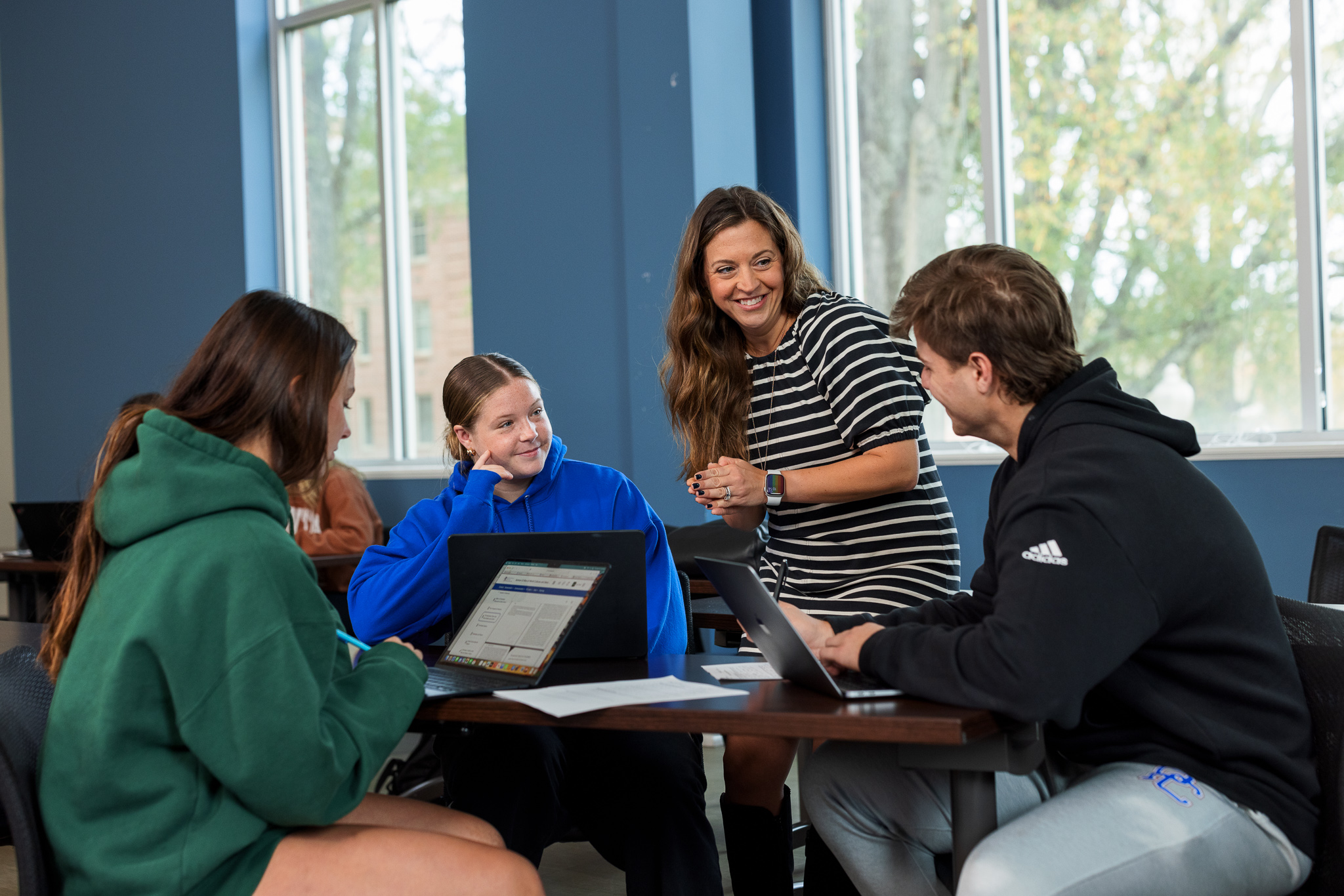 Professor smiling and speaking to students in class