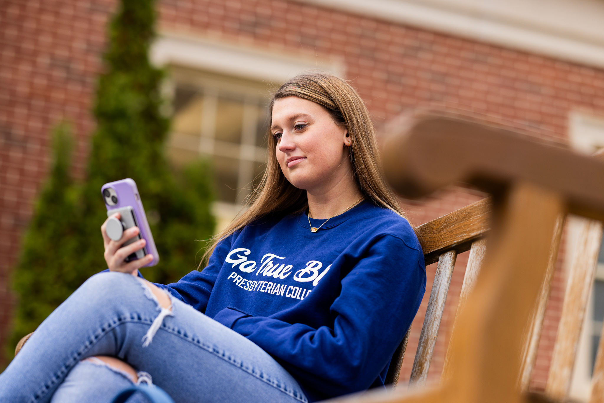 Student sitting on bench and looking at phone