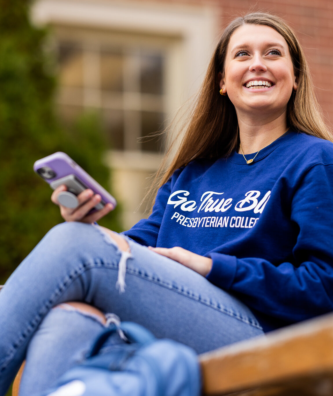 Student sitting on bench and looking at phone